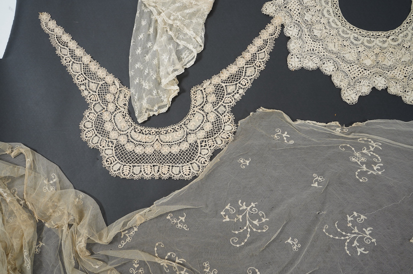 A needle run embroidered net skirt, a similar Bertha, five large silk Maltese bobbin lace collars and trimming, a length of Venetian style lace, mittens etc. Condition - good